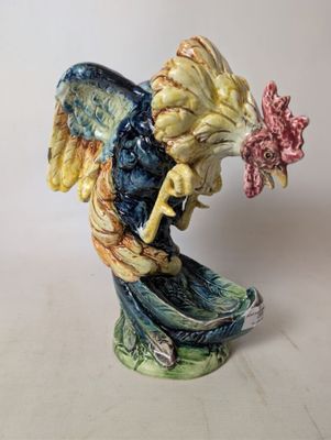 a figurine of a rooster with a flower in its beak