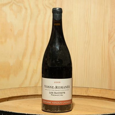 a bottle of wine sitting on top of a wooden barrel