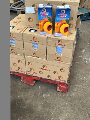 boxes of orange juice are stacked on a pallet in a warehouse