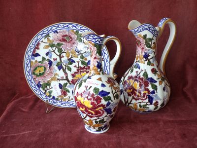 deux vases et une assiette posés sur une nappe rouge