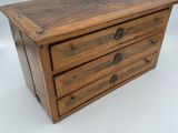 a small wooden box with three drawers on top of it