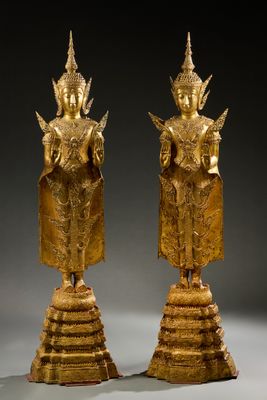 deux statues en or représentant une femme et un homme debout sur un socle