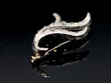 an image of a close up of a silver broochle on a black surface