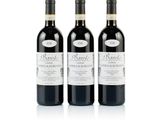 trois bouteilles de vin rouge posées l'une à côté de l'autre sur une surface blanche