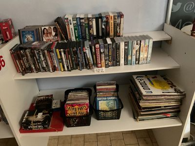 une bibliothèque blanche remplie de livres et de DVD