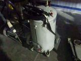 a tank with a toilet and a bucket on the floor
