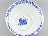 blue and white plate with a woman sitting on a tree branch