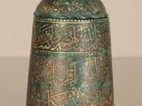 an old metal container with arabic writing on it sitting on a table