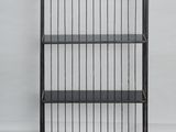 a black metal book shelf with four shelves on top of it