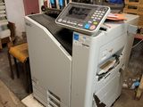 a printer that is sitting in a room next to a chair