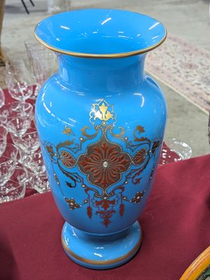 un vase bleu posé sur une table recouverte d'une nappe rouge