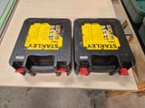 two black and yellow batteries sitting on top of a wooden table