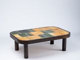 une photo d'une table basse avec un plateau carrelé et des pieds en bois