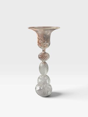 un gros plan d'un vase en verre posé sur une surface blanche