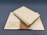 an open book sitting on top of a table next to a piece of paper