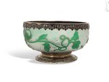 a green and black bowl sitting on top of a table