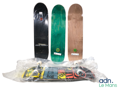 trois skateboards posés les uns à côté des autres sur une surface blanche