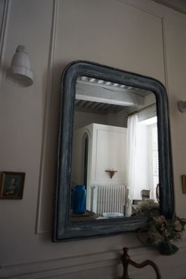 un miroir sur le mur au-dessus d'un lavabo dans une salle de bains