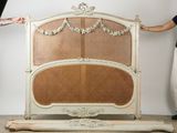a woman standing next to a bed with a wicker headboard