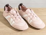a pair of pink sneakers sitting on top of a wooden table