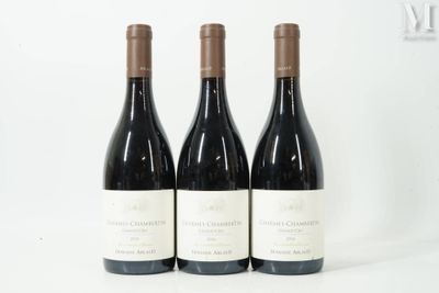 trois bouteilles de vin rouge sont alignées sur une surface blanche