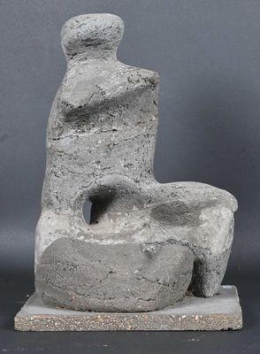 sculpture of a man sitting on a rock on a gray surface