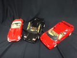 three toy cars that are sitting on a black surface