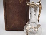 un vase en argent posé à côté d'une boîte marron