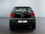 the back end of a small black car in a white room