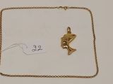 un collier en or orné d'un pendentif en forme de poisson doré