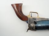 an old revolver with a wooden handle on a white wall