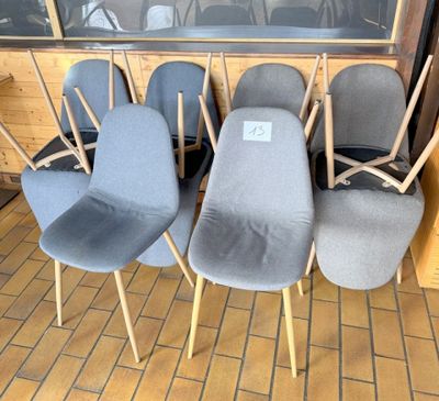 Plusieurs chaises sont alignées en rang devant une fenêtre.