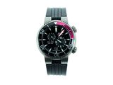 La montre est noire et présente une touche de rose sur le cadran.