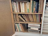 a book shelf full of books on a hard wood floor