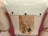 a wooden mannequin that has a label on it