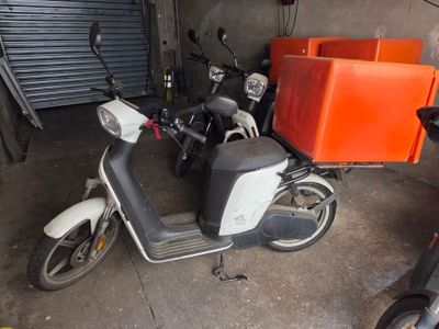 un scooter garé dans un garage à côté d'autres scooters