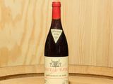 une bouteille de vin posée sur un tonneau en bois