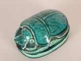 a ceramic scarab sitting on top of a white surface