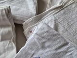 several white towels on a bed with a blue tag on them
