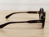 a close up of a pair of sunglasses on a wooden table