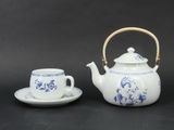 a tea pot and a cup sitting on a table