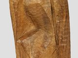 wooden sculpture of a man sitting on a chair with his back to the camera