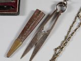 two pairs of scissors on a chain next to a box