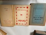 several old books are stacked on a shelf in a room