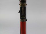 a black and red pen sitting on top of a wooden stand