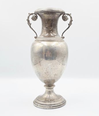 a silver vase that is sitting on a table