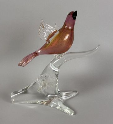 a glass bird that is sitting on top of a branch