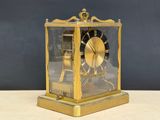 a gold clock that is sitting on a table