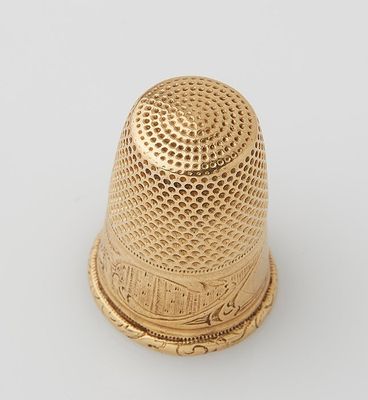 a gold thimble on a white background