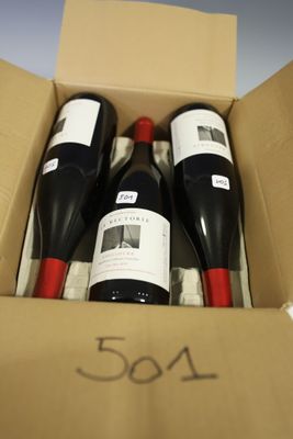 three bottles of wine in a box with a price tag